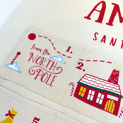 Lifestyle shot of the personalised fabric advent calendar in a festive Christmas living room setting.